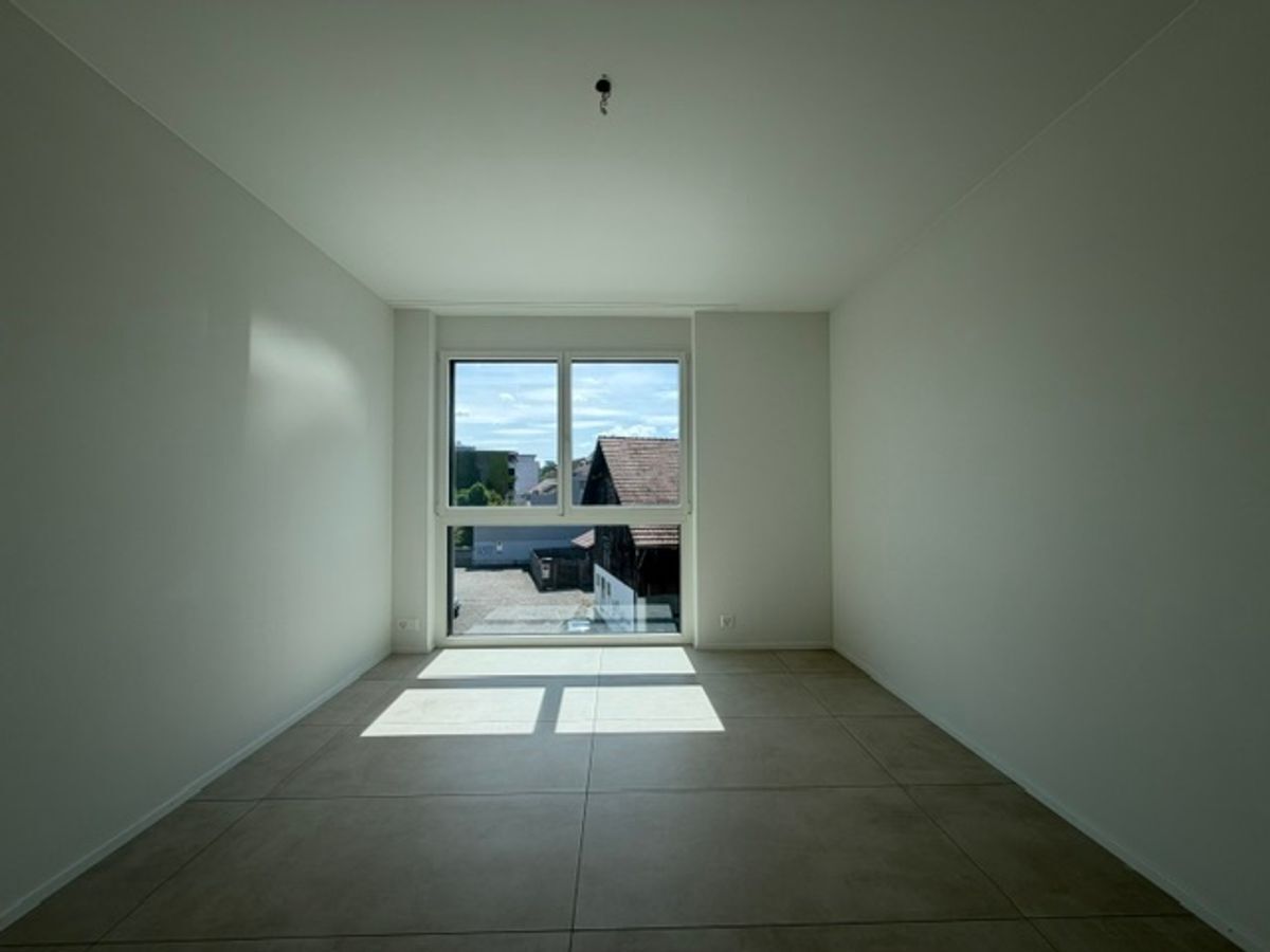 Lichtdurchfluteter Raum mit grossem Fenster und Fliesenboden. Lichtdurchfluteter Raum mit grossem Fenster und Fliesenboden.