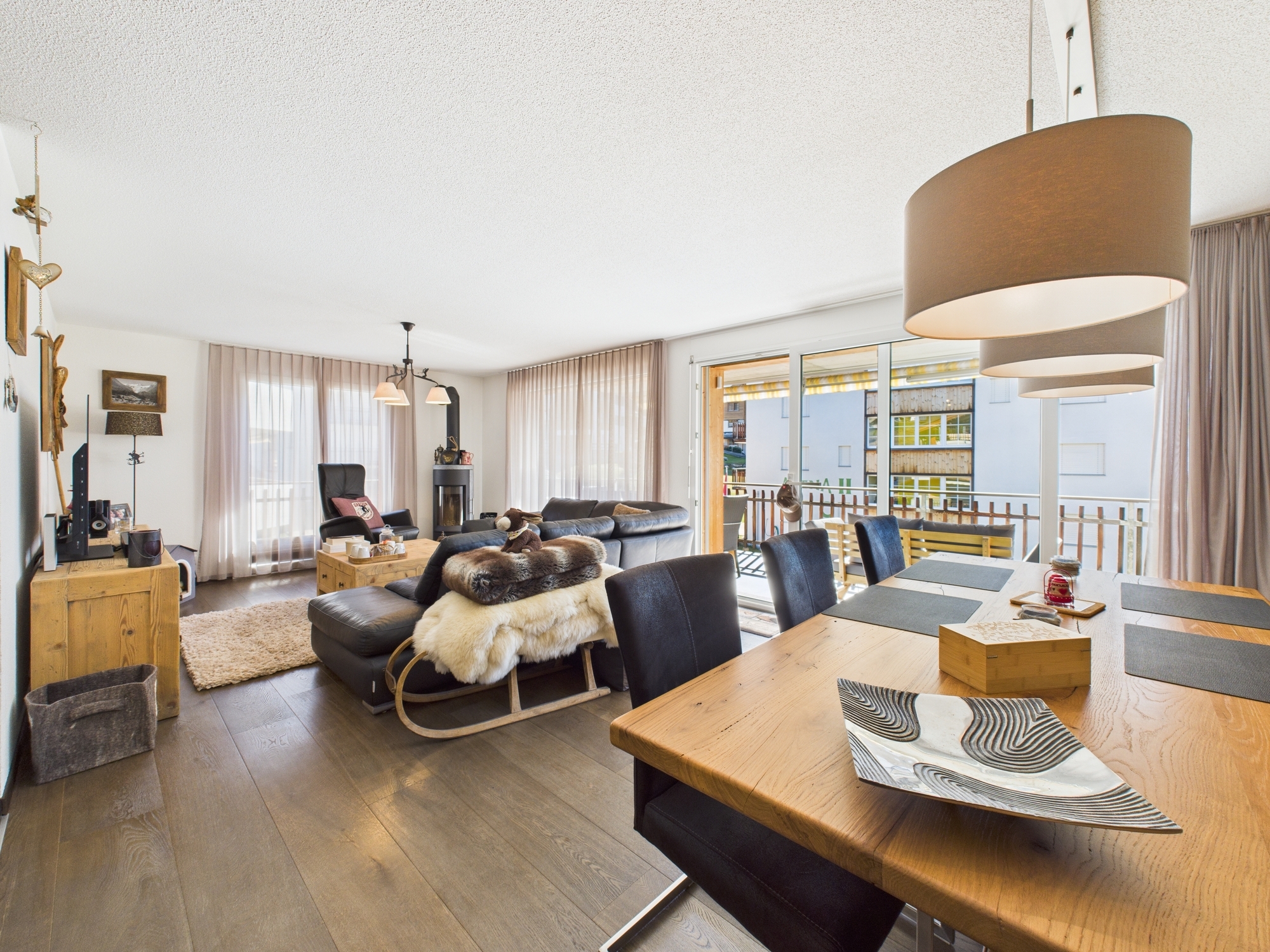 ein großer Raum mit Wohnzimmer, Esszimmer und Küche mit Holztisch und Stühlen