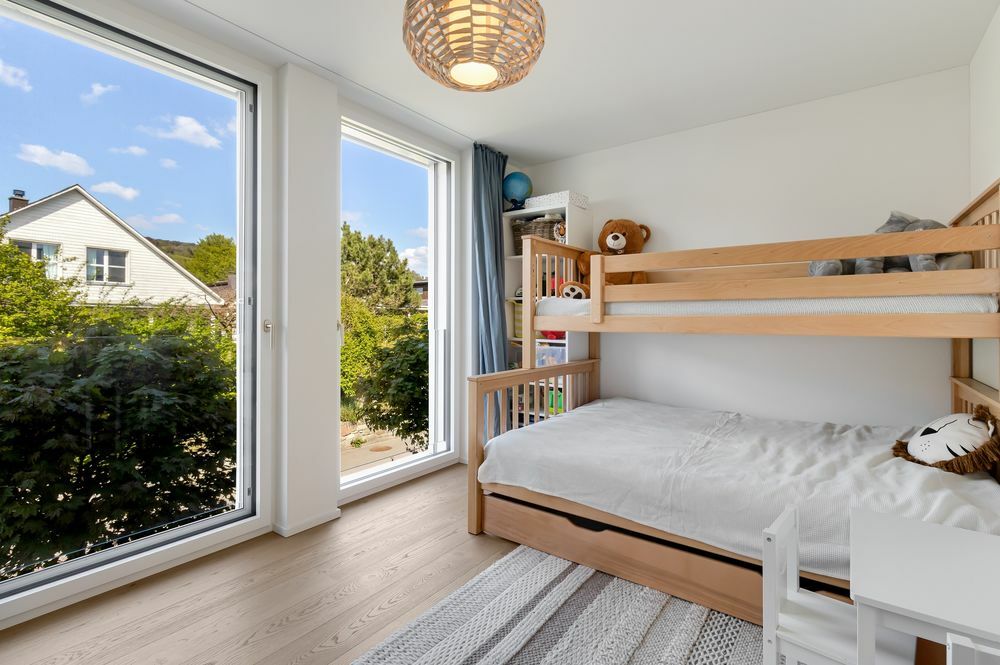 une chambre avec un lit superposé et une grande fenêtre une chambre avec un lit superposé et une grande fenêtre