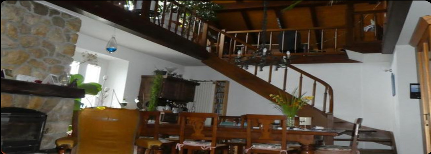 un salon et une salle à manger avec des meubles en bois, une table et des chaises et un escalier menant au deuxième étage d'une maison un salon et une salle à manger avec des meubles en bois, une table et des chaises et un escalier menant au deuxième étage d'une maison