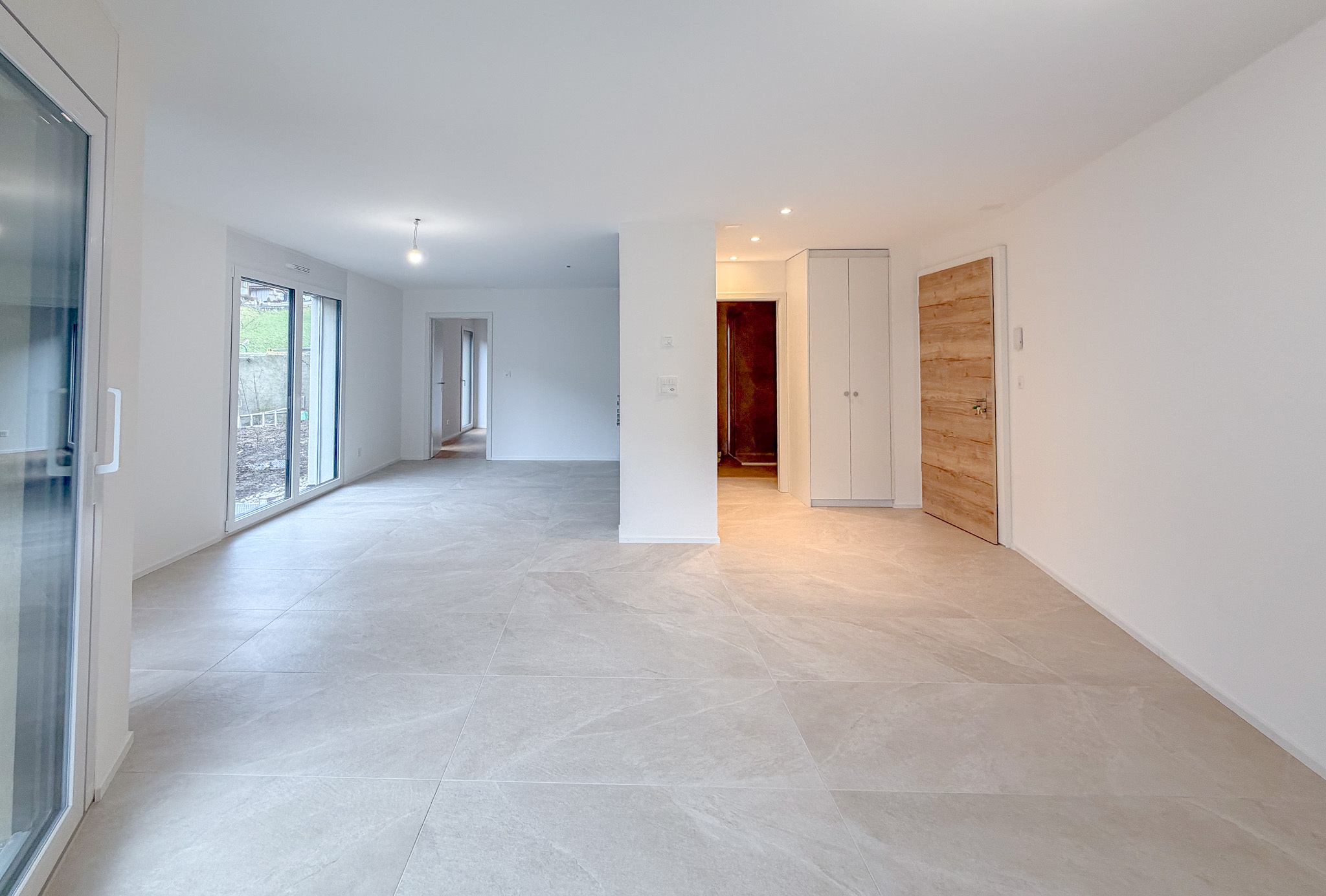 Espace salon/séjour avec portes-fenêtres donnant accès à la terrasse et au jardin privatif