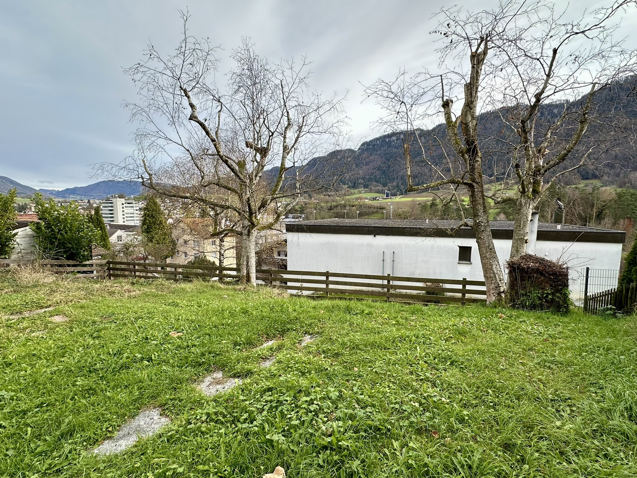 une maison blanche sur une colline avec des arbres et des montagnes en arrière-plan une maison blanche sur une colline avec des arbres et des montagnes en arrière-plan