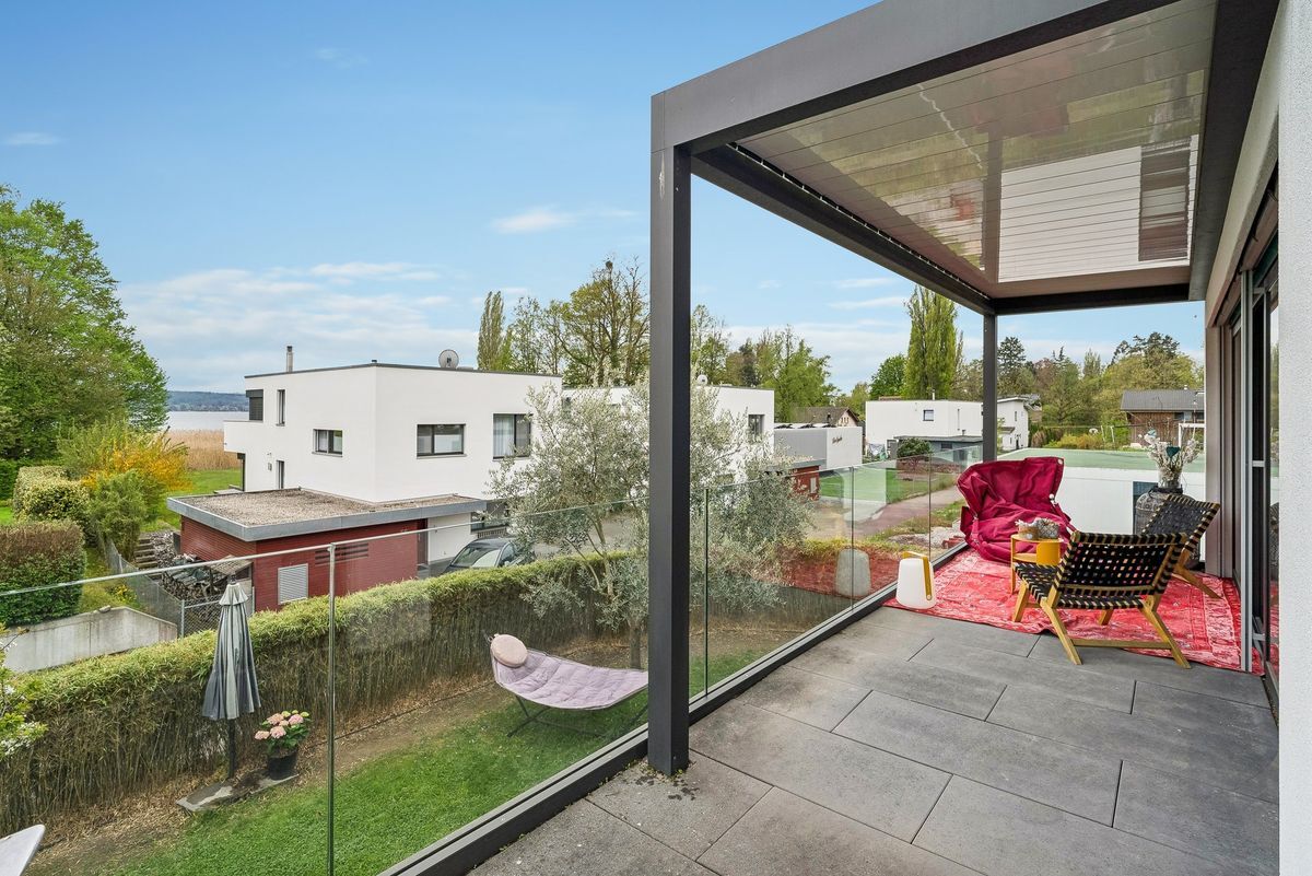 Terrasse avec vue sur le jardin et maisons voisines.