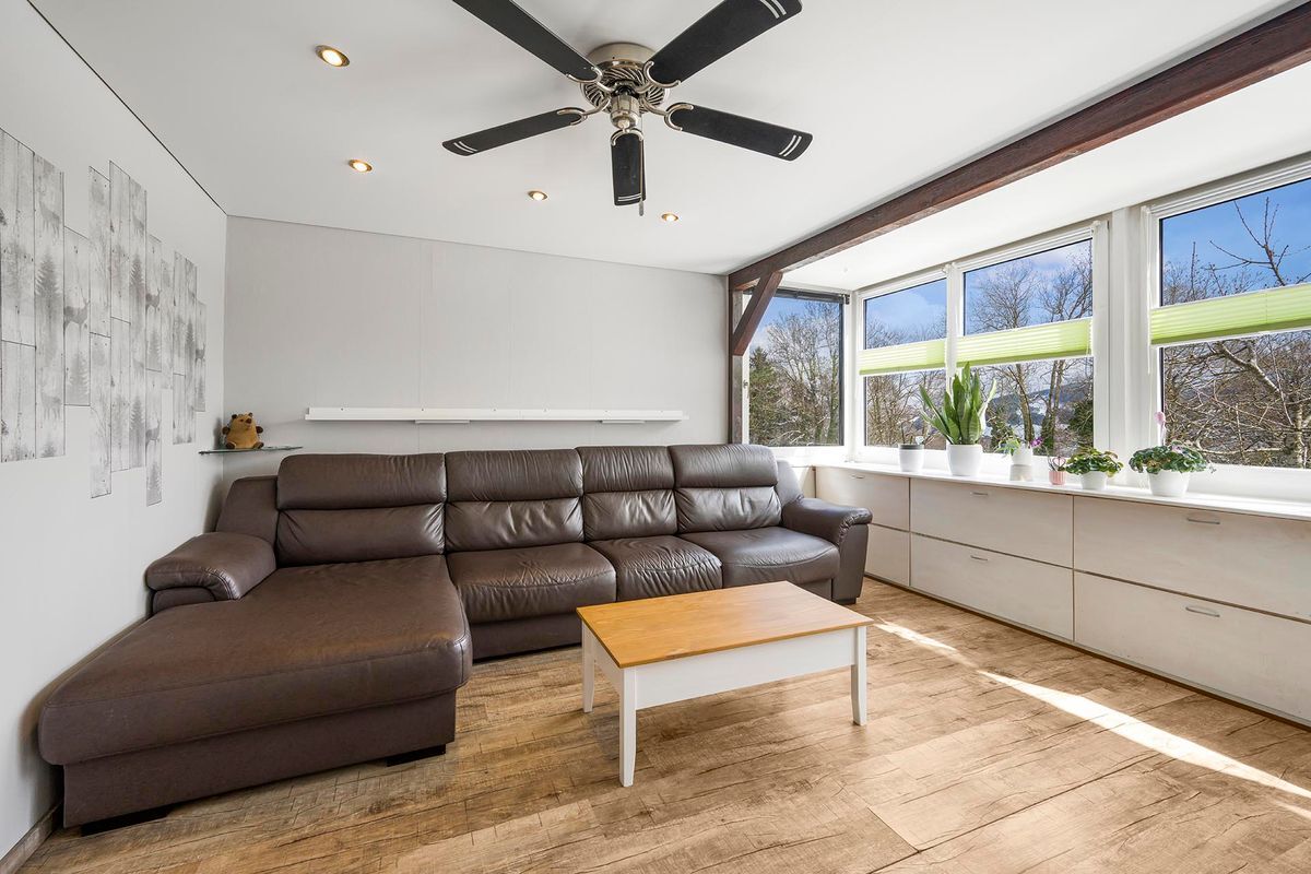 Gemütliches Wohnzimmer mit großem Sofa und Panoramafenstern.