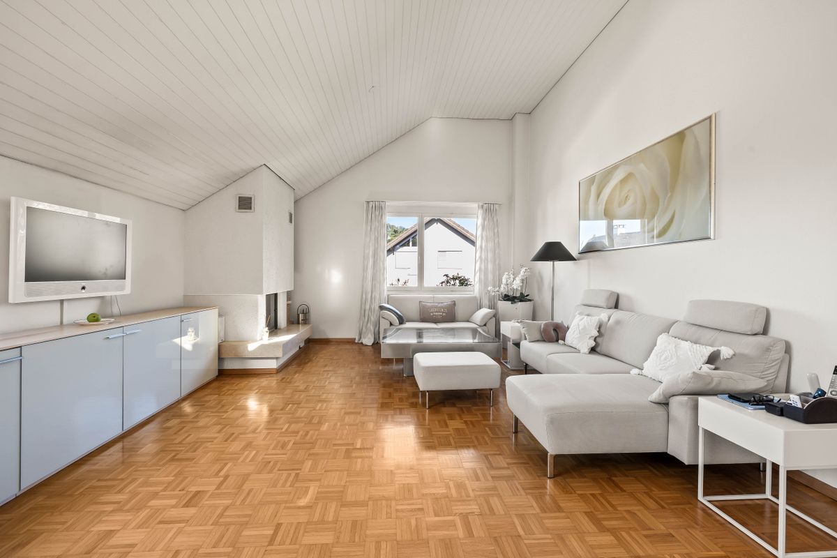 Helles Wohnzimmer mit Parkettboden und modernem Mobiliar.