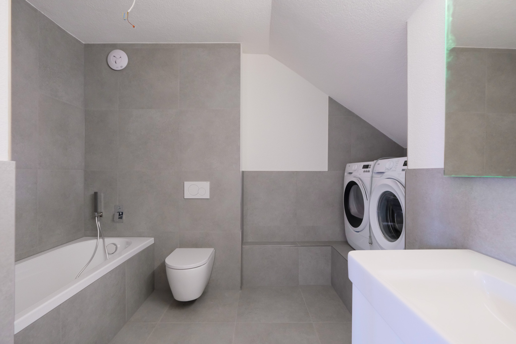 Bathroom with bathtub and washing machine / tumble dryer