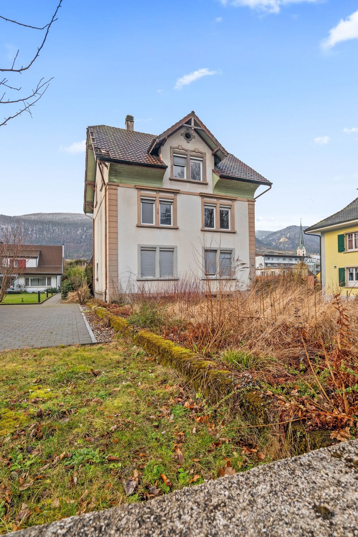 Zweistöckige Fassade mit Garten in ruhiger Nachbarschaft.