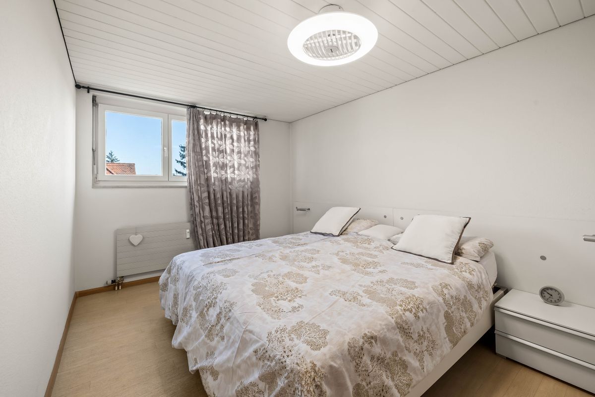 Geräumiges Schlafzimmer mit Doppelbett und grossem Fenster.