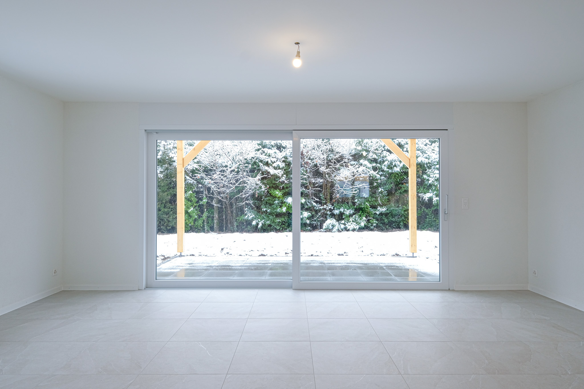 Villas construites aux Cullayes : une grande baie vitrée avec vue sur la terrasse.