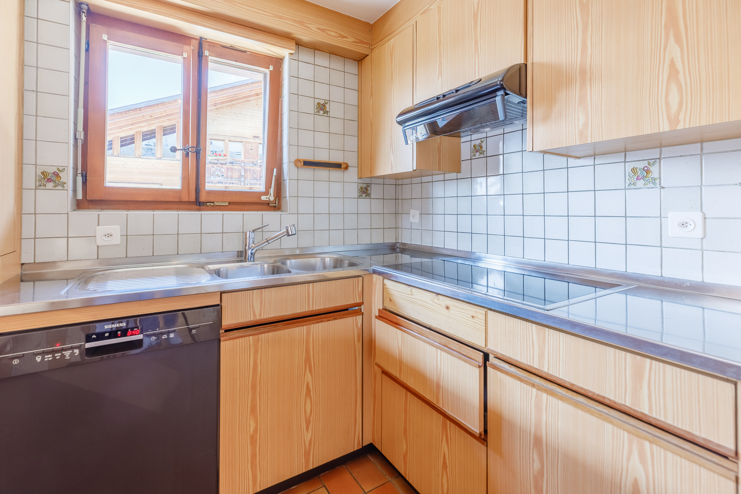 une cuisine avec un évier, un lave-vaisselle et une fenêtre