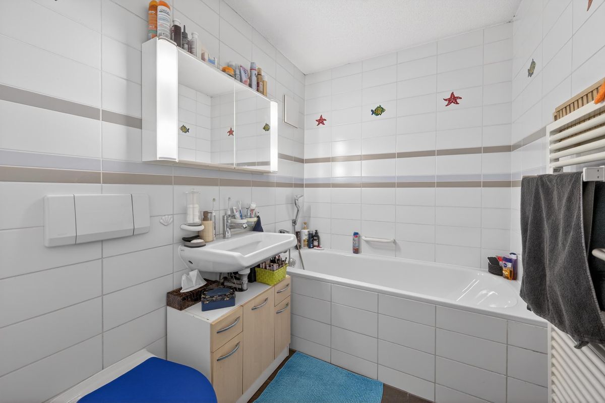 Kompaktes Badezimmer mit Badewanne und Spiegelbeleuchtung. Kompaktes Badezimmer mit Badewanne und Spiegelbeleuchtung.