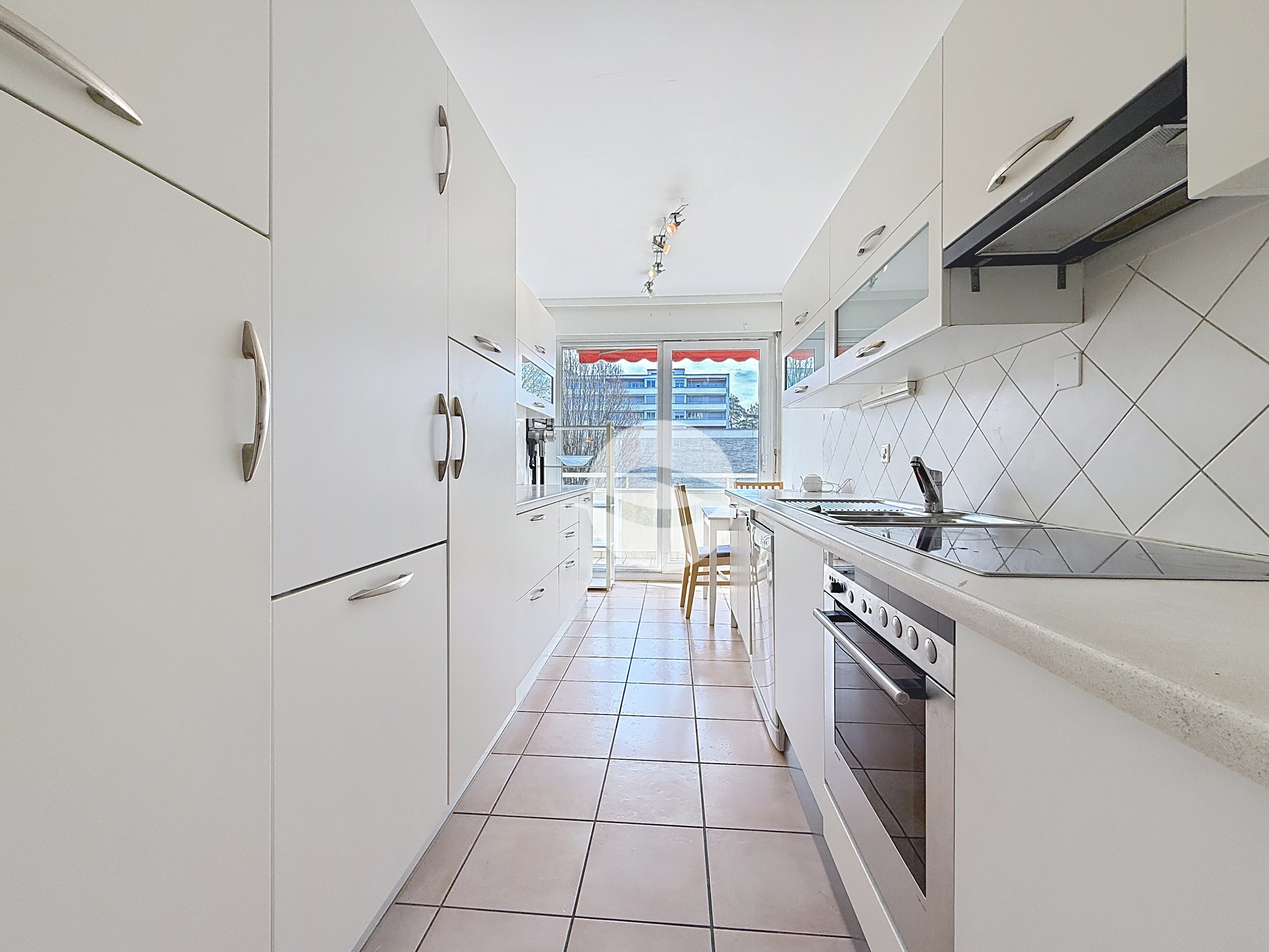 Cuisine équipée avec coin repas et accès balcon