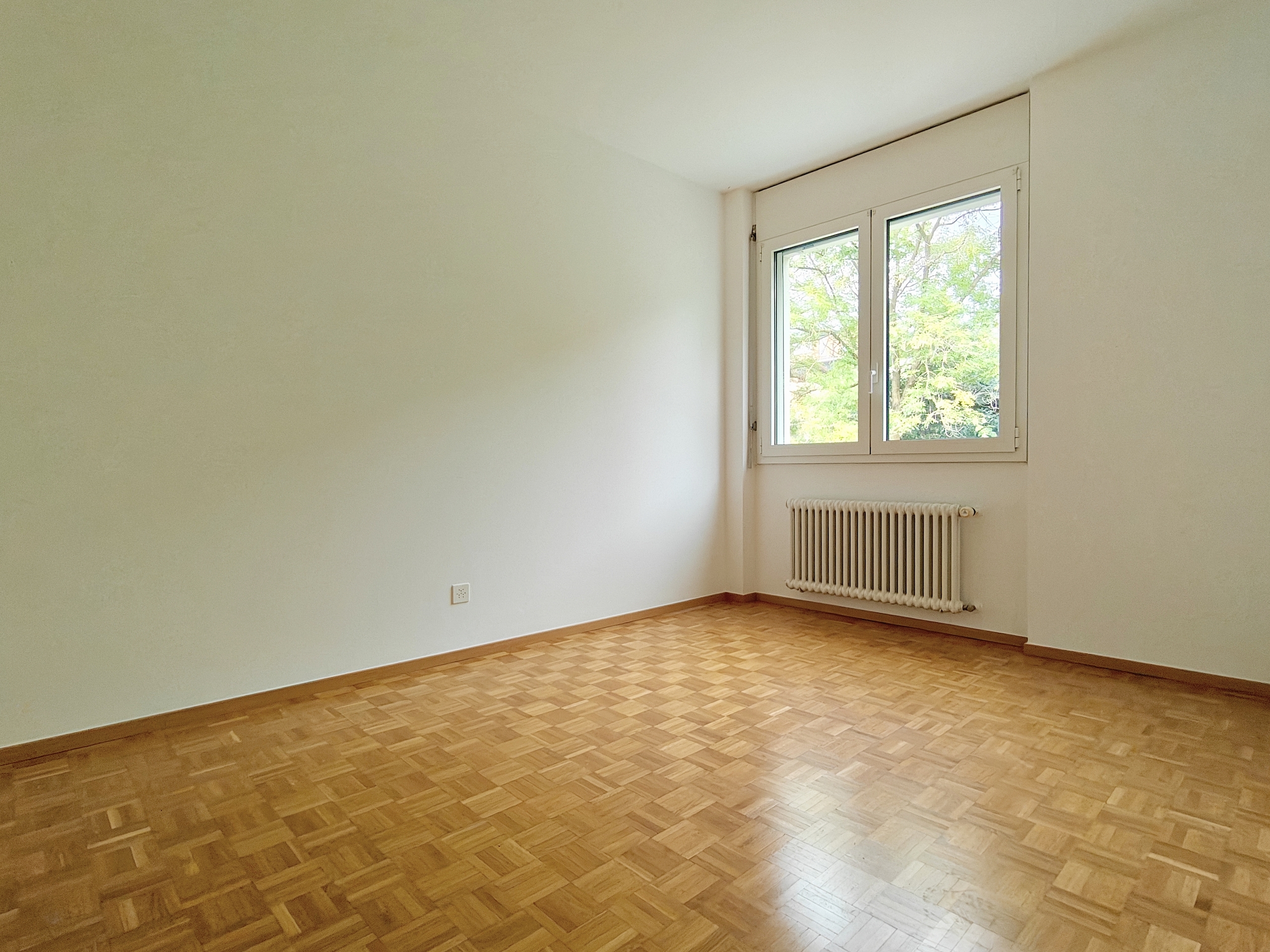 an empty room with white walls and a large window an empty room with white walls and a large window