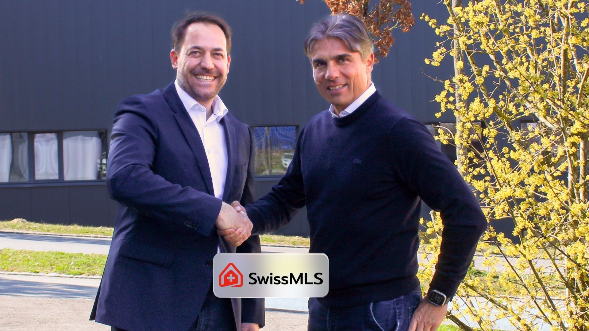 Deux professionnels se serrent la main lors du lancement de SwissMLS, réseau de diffusion d’annonces immobilières en Suisse.