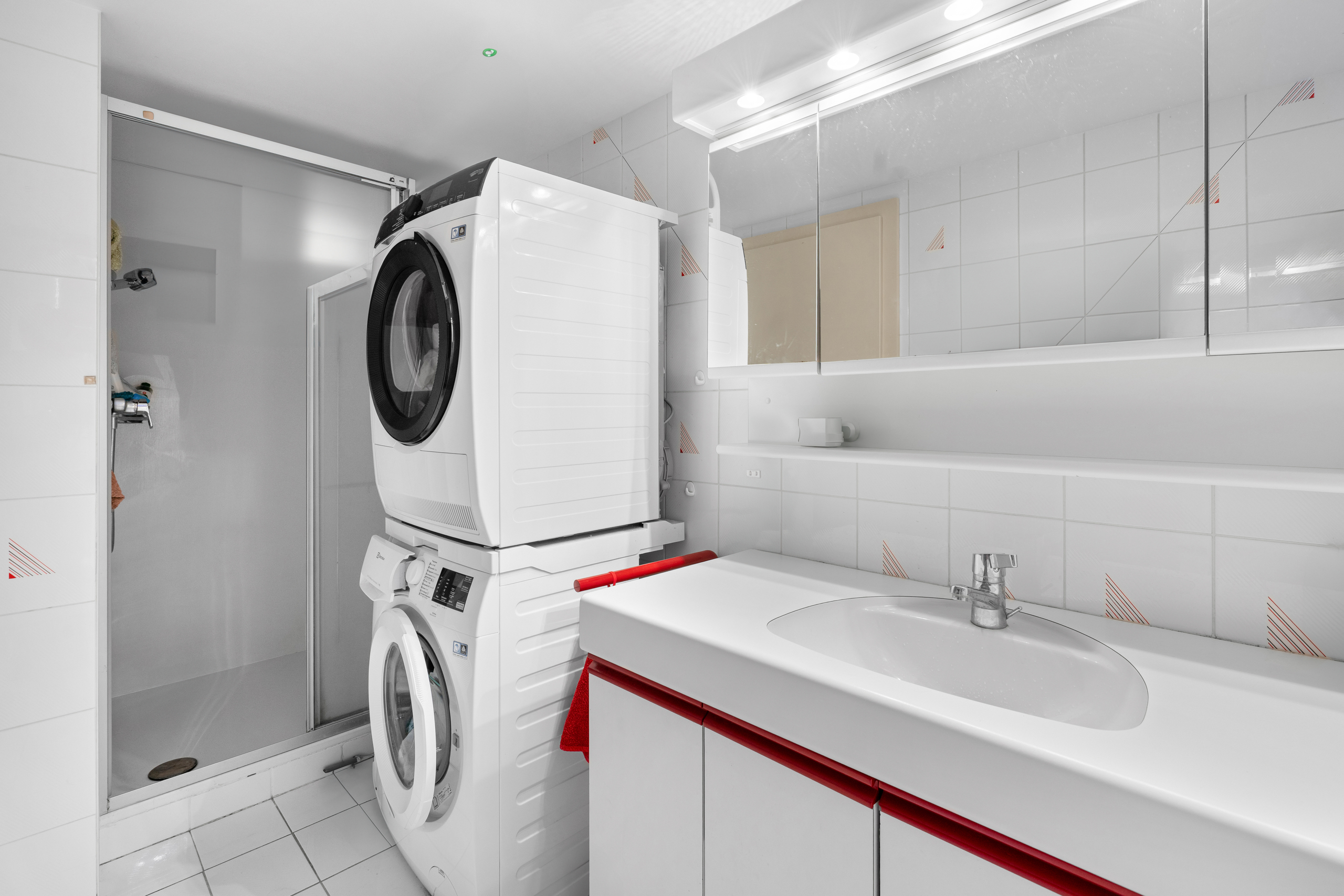 une salle de bain blanche avec un lave-linge et un lavabo une salle de bain blanche avec un lave-linge et un lavabo