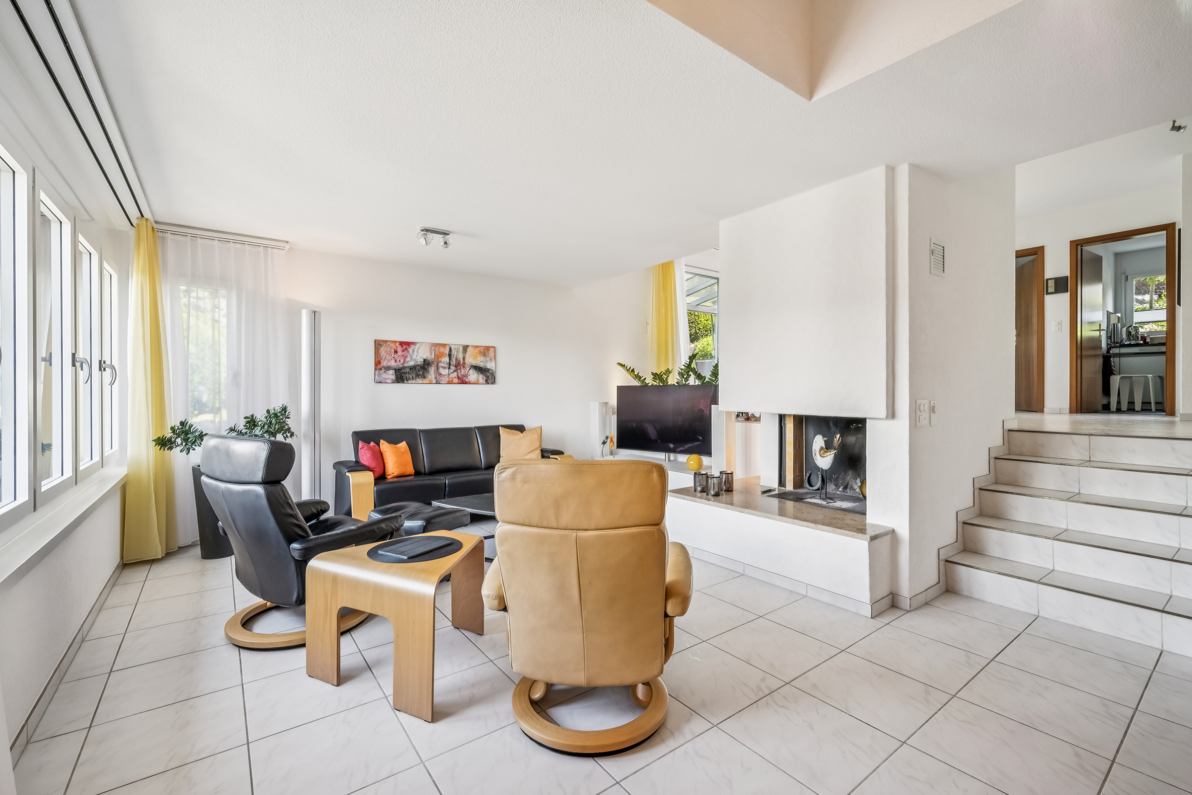 Wohnzimmer in Split-Level-Bauweise mit Cheminée.