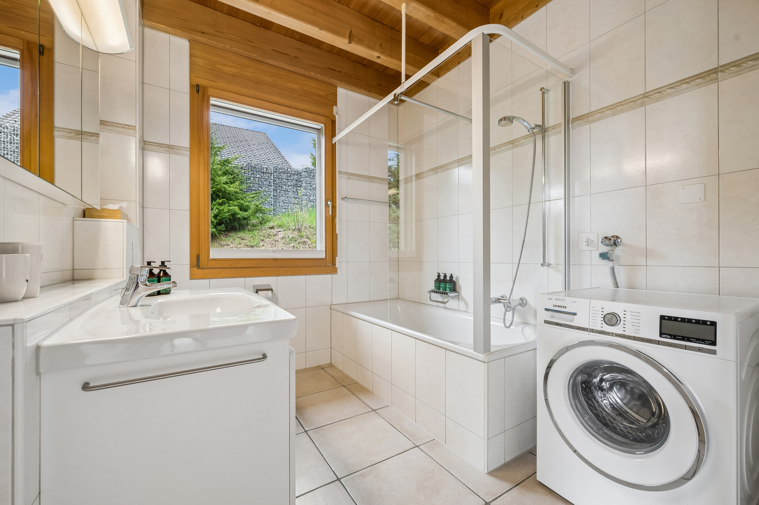 Badezimmer mit Badewanne und Waschmaschine