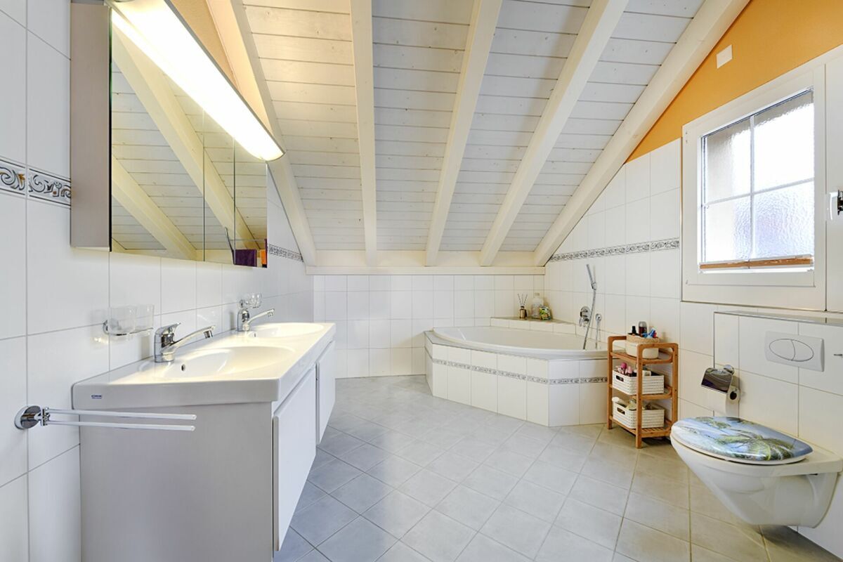 Grosszügiges Badezimmer mit Doppellavabo, Toilette und Fenster