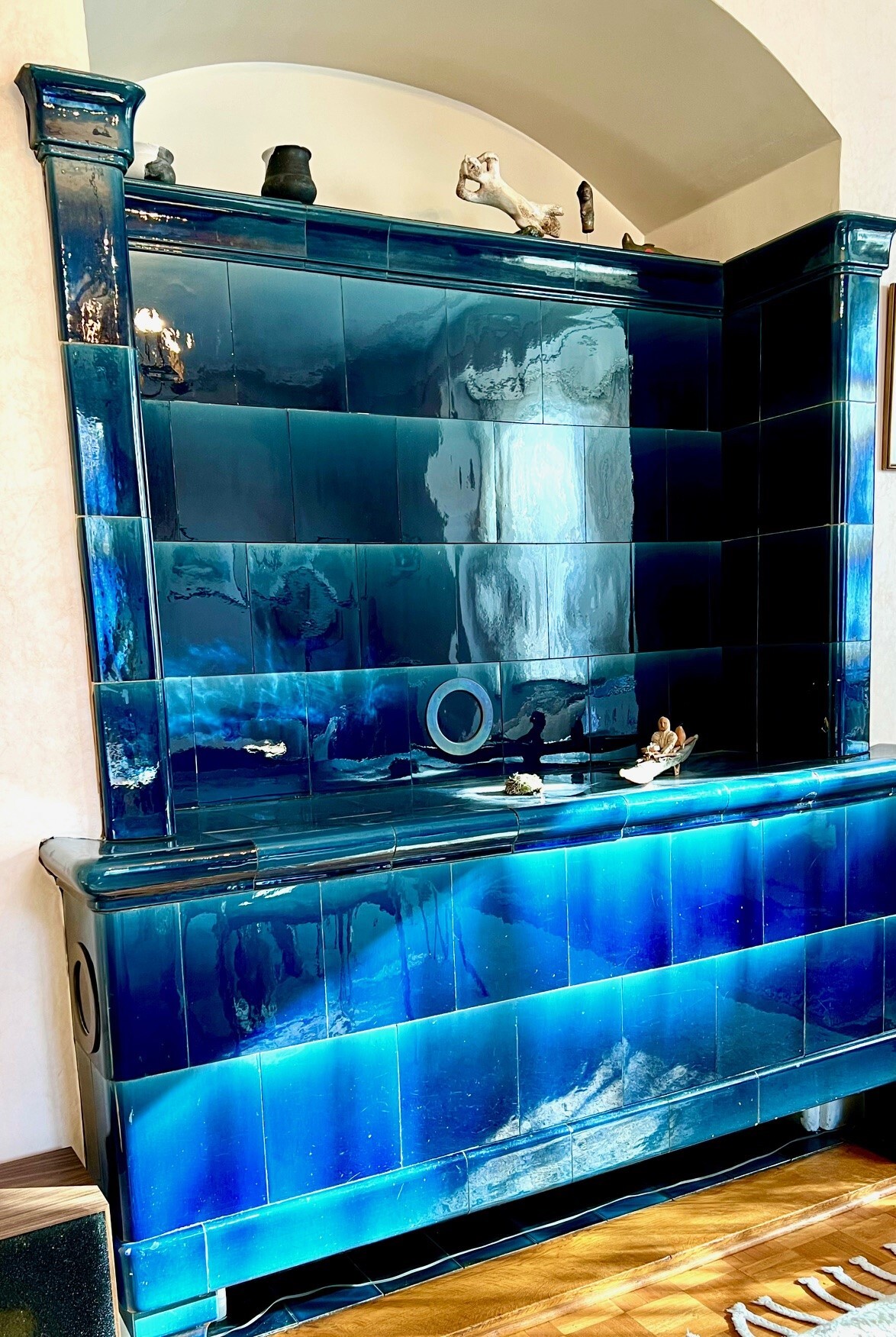 a room with a wall of blue tiles and glass