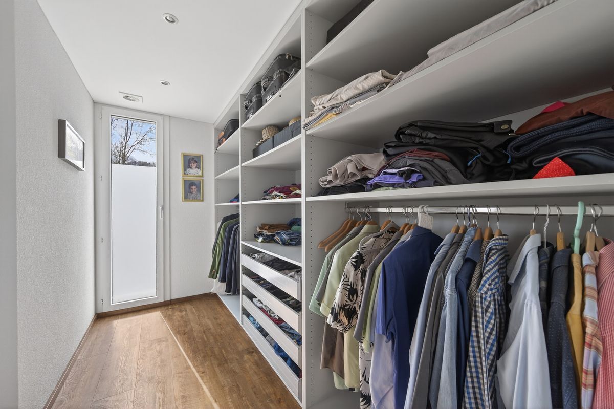 Geräumige Ankleide mit offenen Regalen und Hängestangen