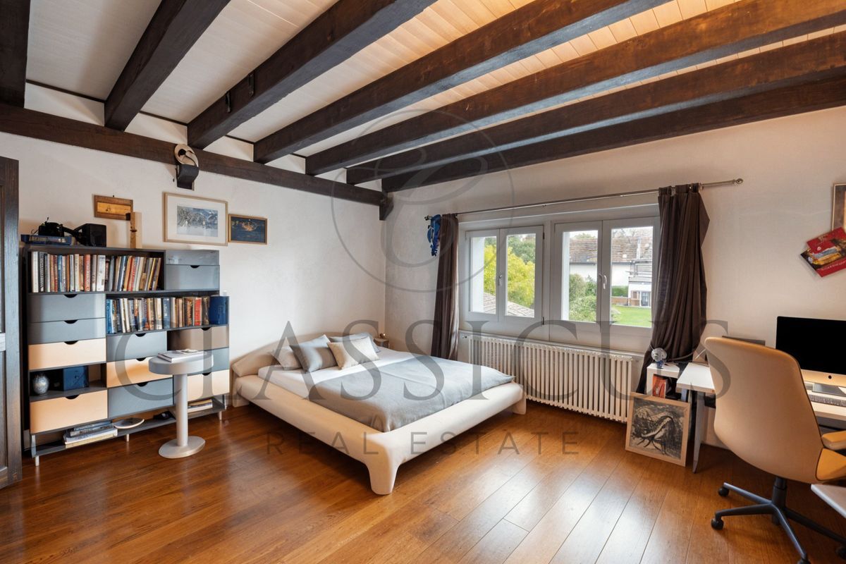 Chambre avec poutres apparentes et bureau près de la fenêtre. Chambre avec poutres apparentes et bureau près de la fenêtre.