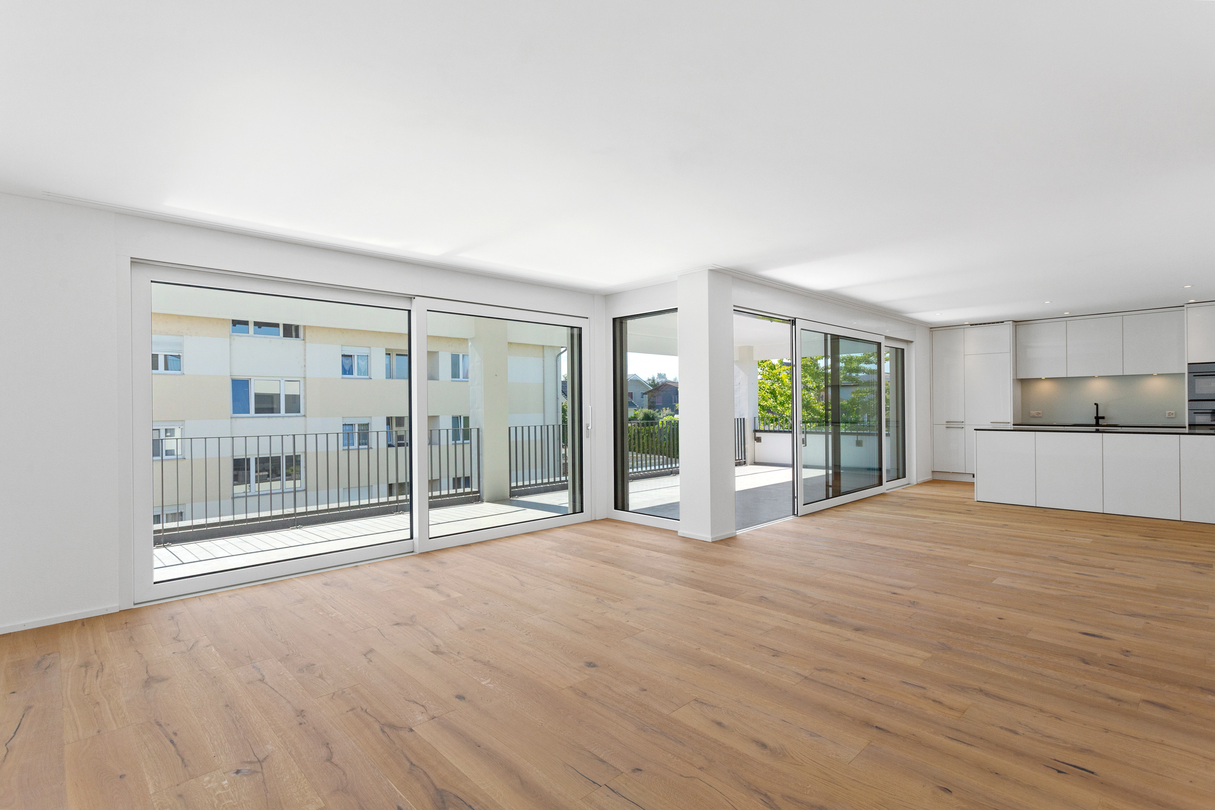 Helle Weite, klares Design prägen die offene moderne Küche und den Wohn-Essbereich, der sich direkt zum grossen, überdachten Balkon hin öffnet. Helle Weite, klares Design prägen die offene moderne Küche und den Wohn-Essbereich, der sich direkt zum grossen, überdachten Balkon hin öffnet.