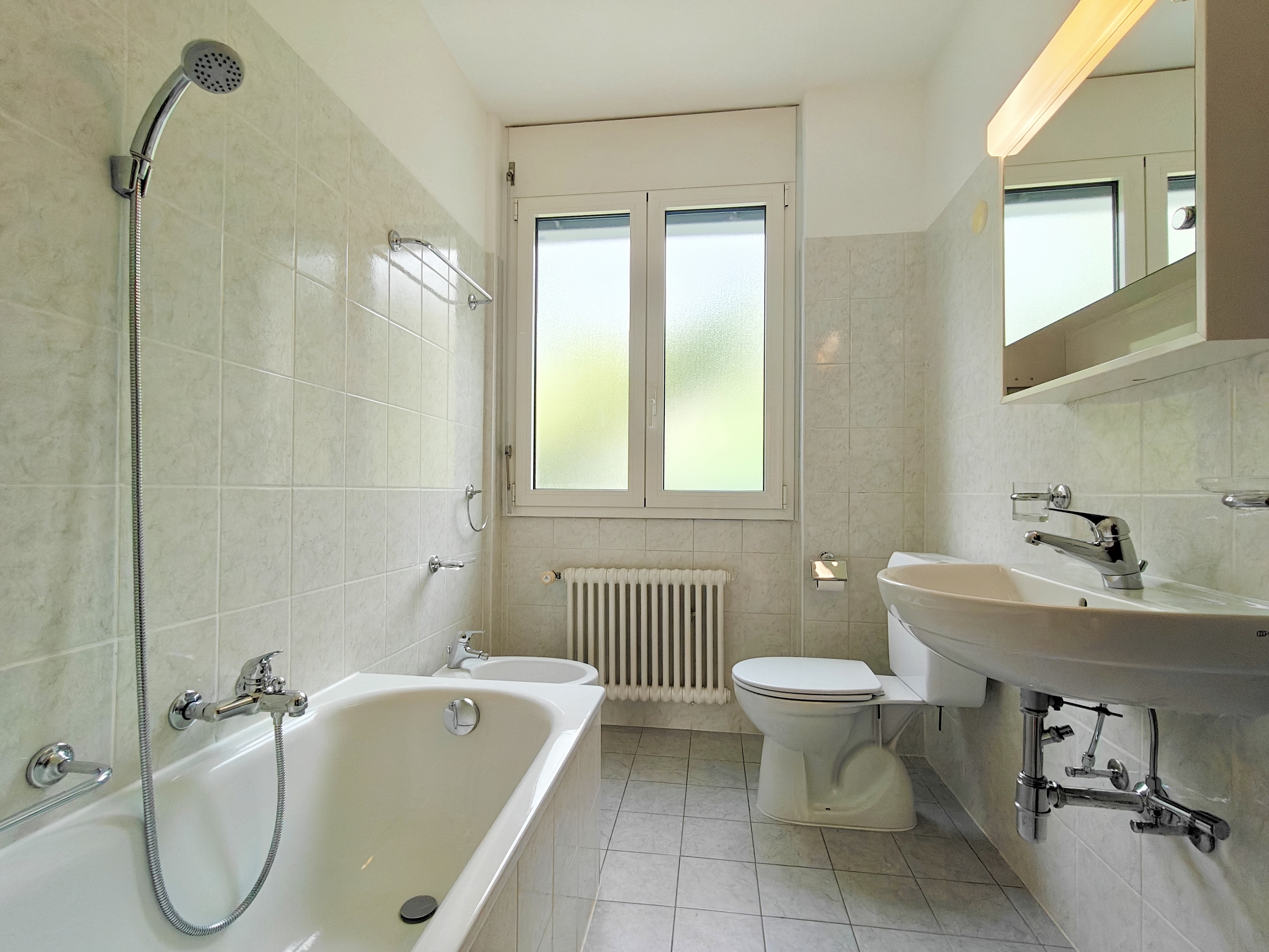 a white bathroom with a tub, sink, toilet and shower a white bathroom with a tub, sink, toilet and shower
