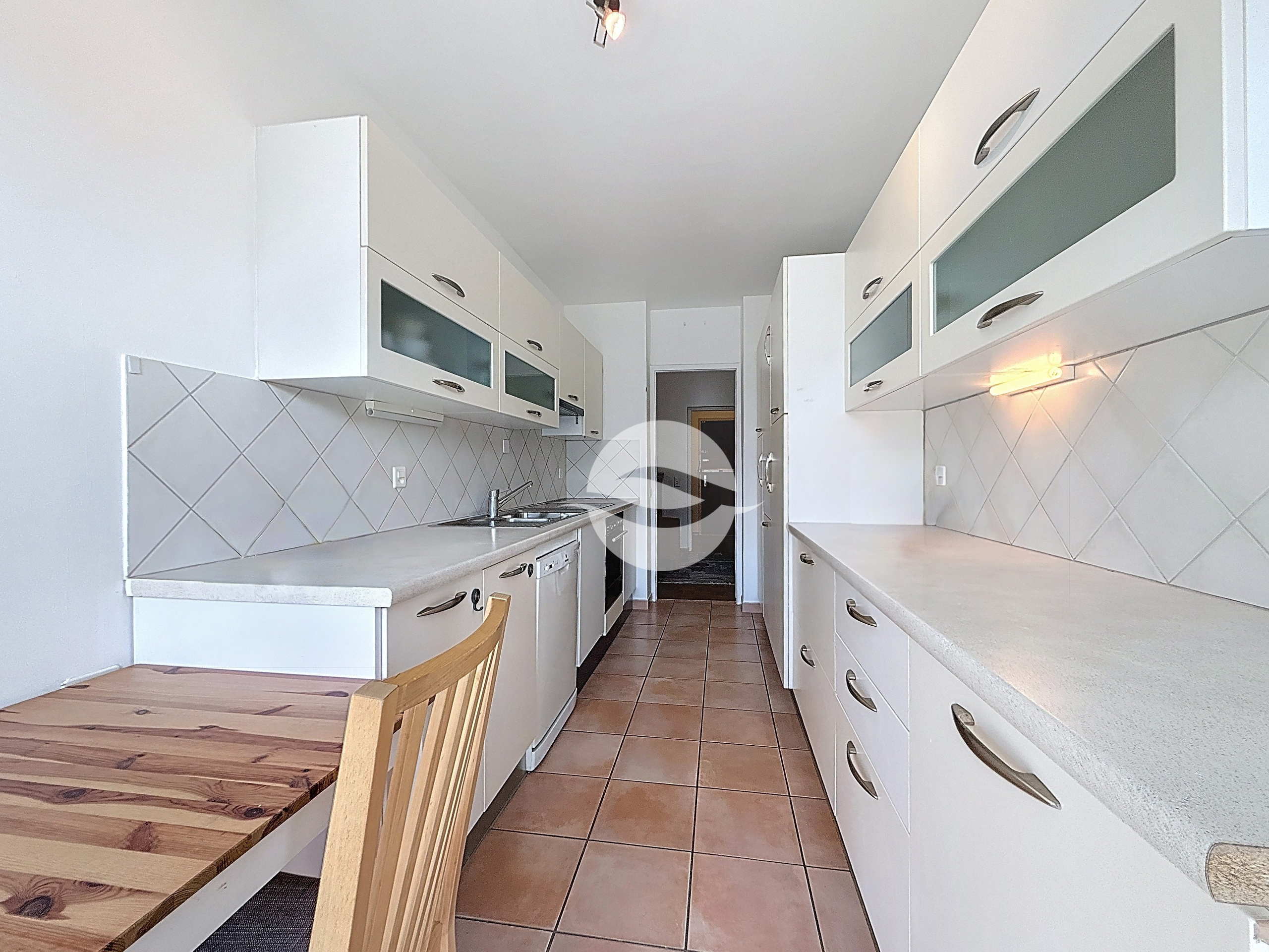 Cuisine équipée avec coin repas et accès balcon