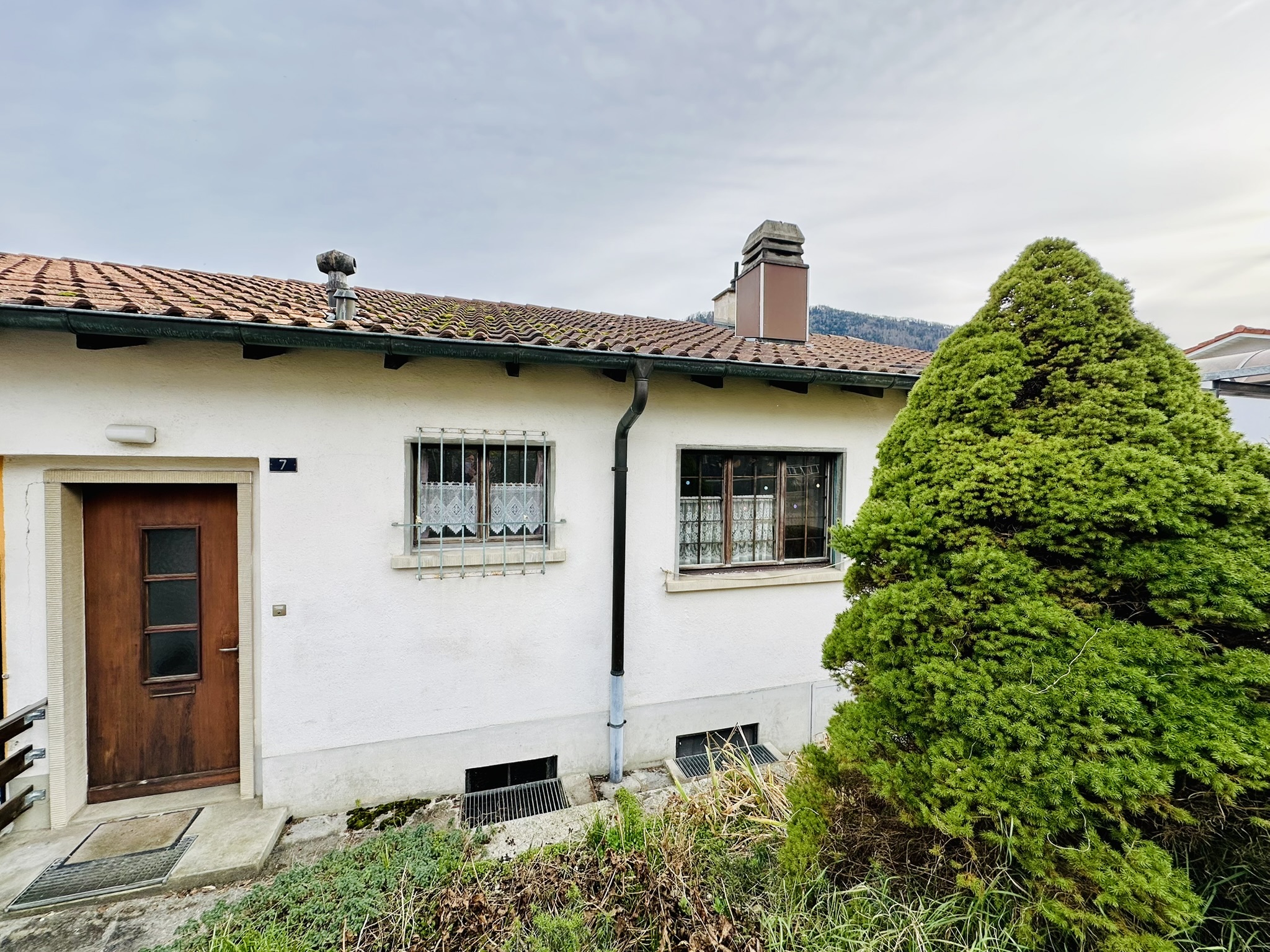un vieux bâtiment devant lequel se trouve un petit arbre un vieux bâtiment devant lequel se trouve un petit arbre