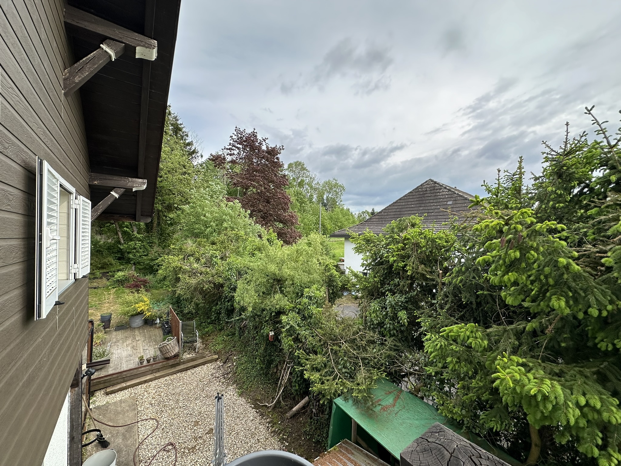 la cour arrière d'une maison avec une terrasse et des arbres dans la cour