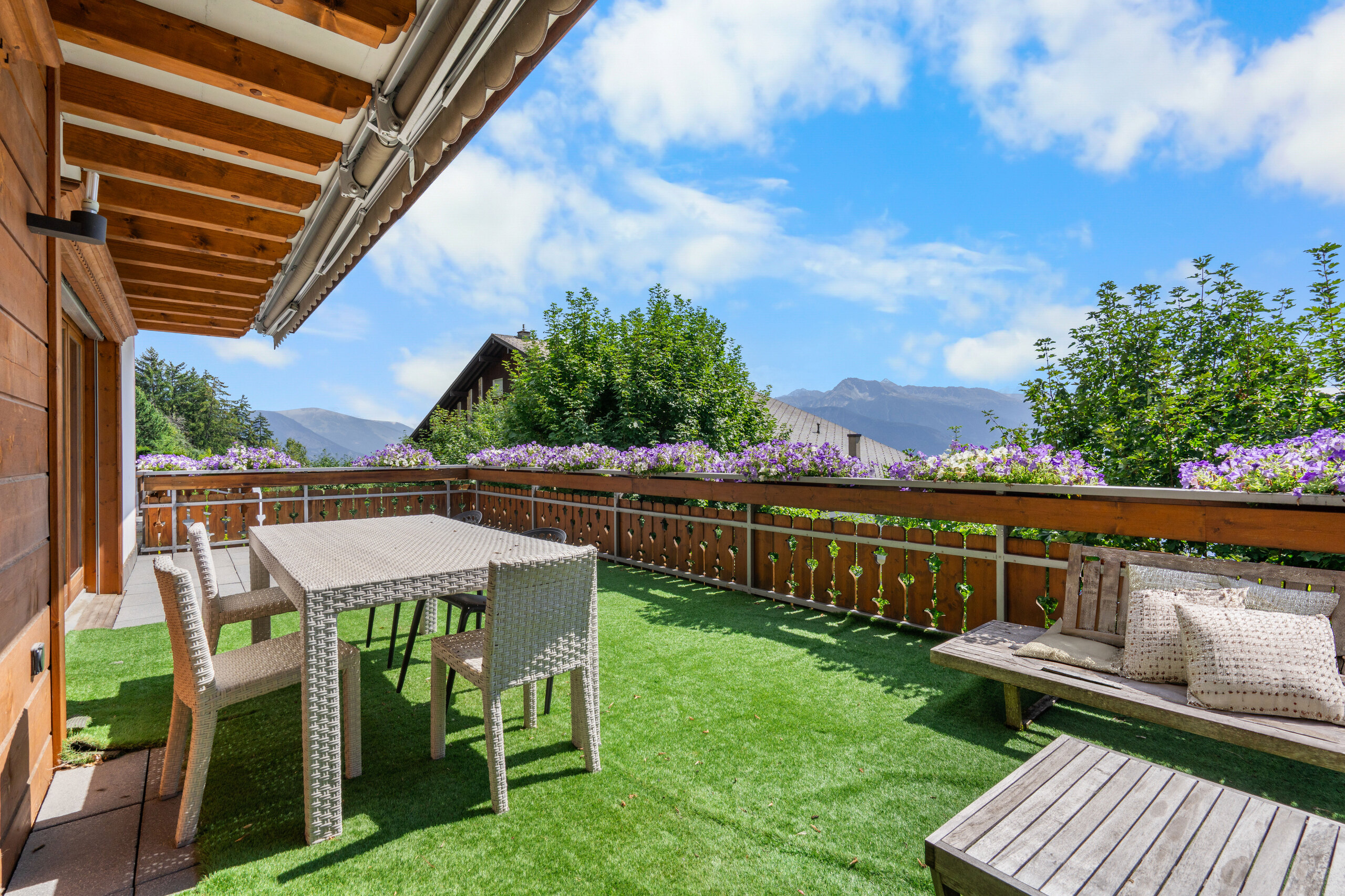 une terrasse en bois ou un patio avec une table et des chaises donnant sur les montagnes